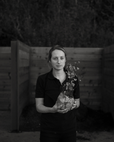 Portrait of woman holding sapling. Black and white.