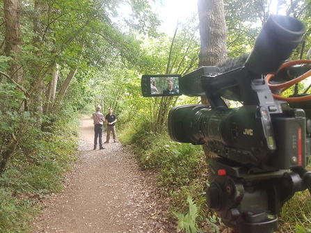 View behind a camera filming DWT staff in woodlands