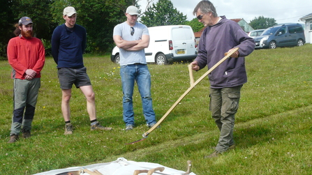 Buckfastleigh Action for Nature Group (BANG) members learning how to use a scythe
