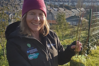 Helen holding up young tree