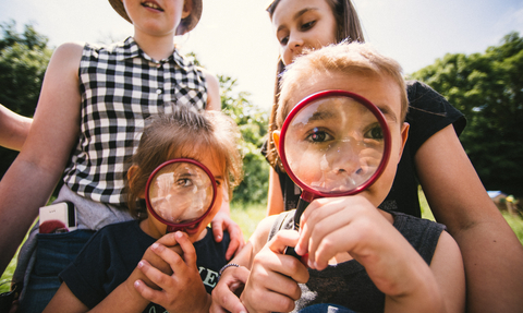 Children at an event using magnifying glasses