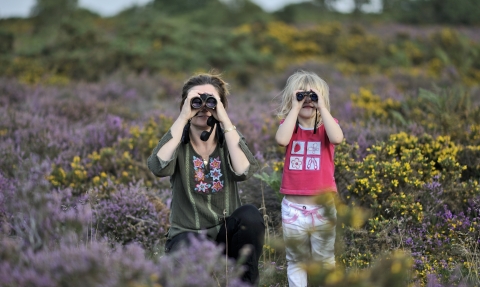 Happy family birdwatching among heather