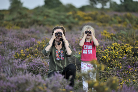 Happy family birdwatching among heather