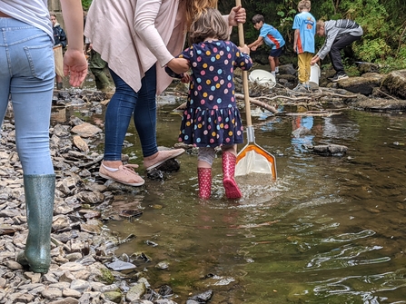 People with nets surveying river biodiversity