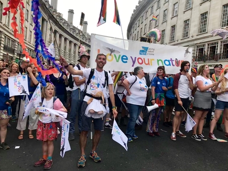 Nick Bruce-White marching in Pride parade with 'love your nature' banner