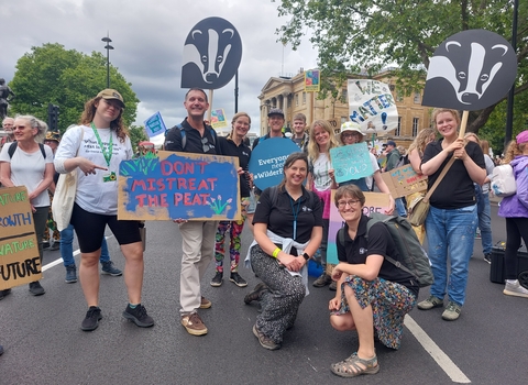 Group of DWT staff and supporters holding placards on road